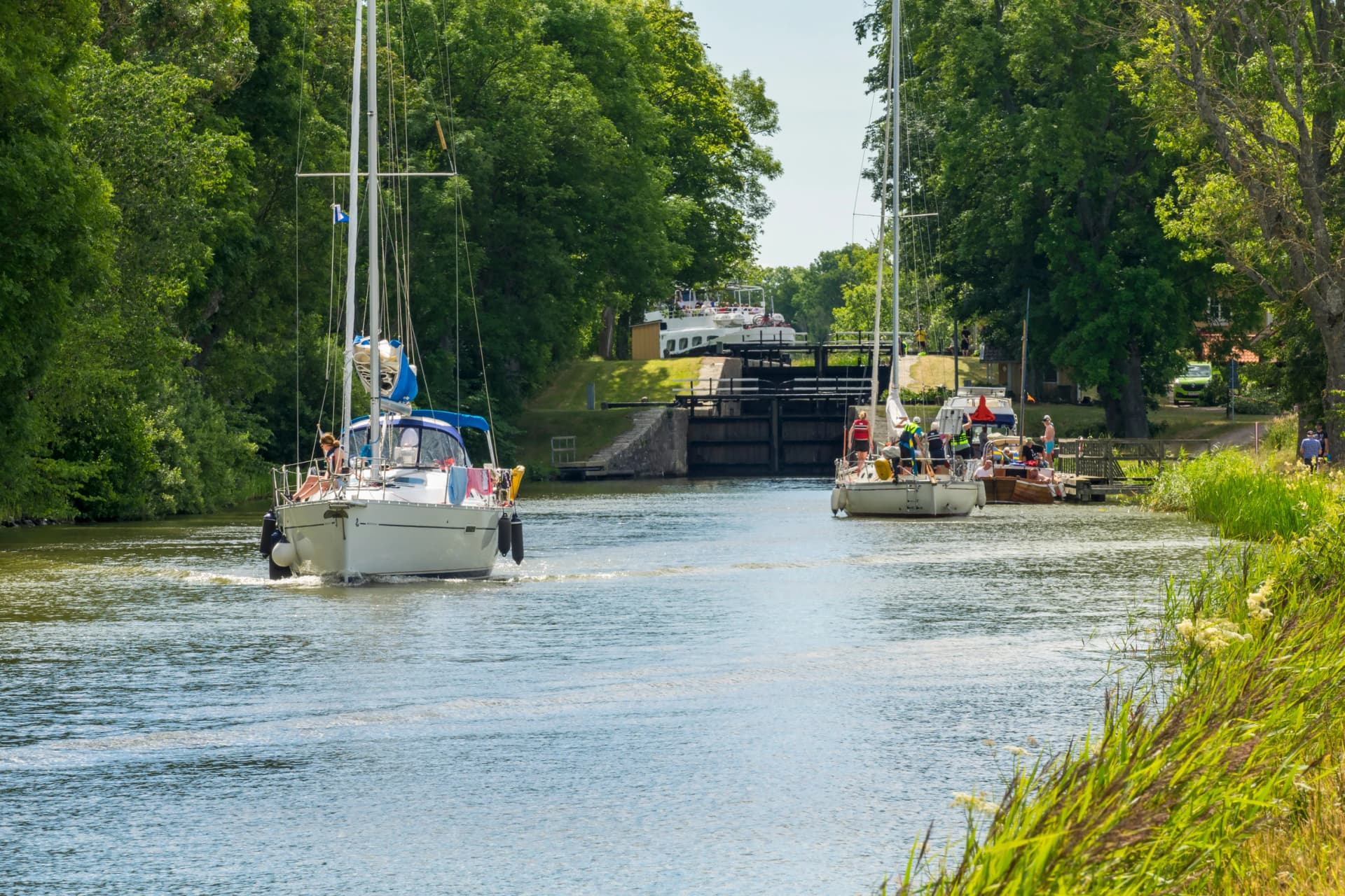 Sailboats at a lock in a canal on a sunny summer day