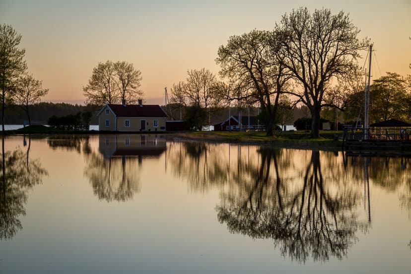 Reflection of trees in the calm waters of Sjötorp marina lock system that connects lake vänern to the göta canal after sunset.