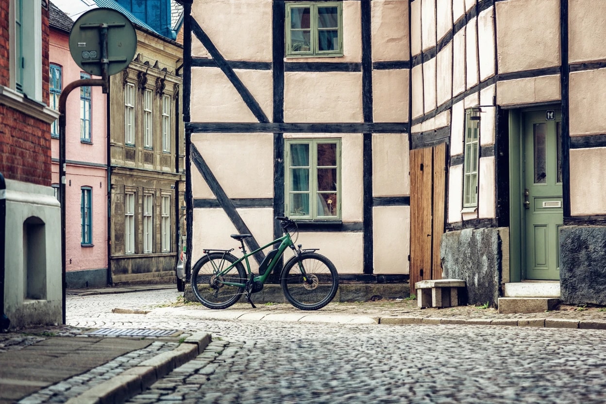 Yellow bicycle near the building facade with a window, Scandinavian style. Street in Lund, Sweden