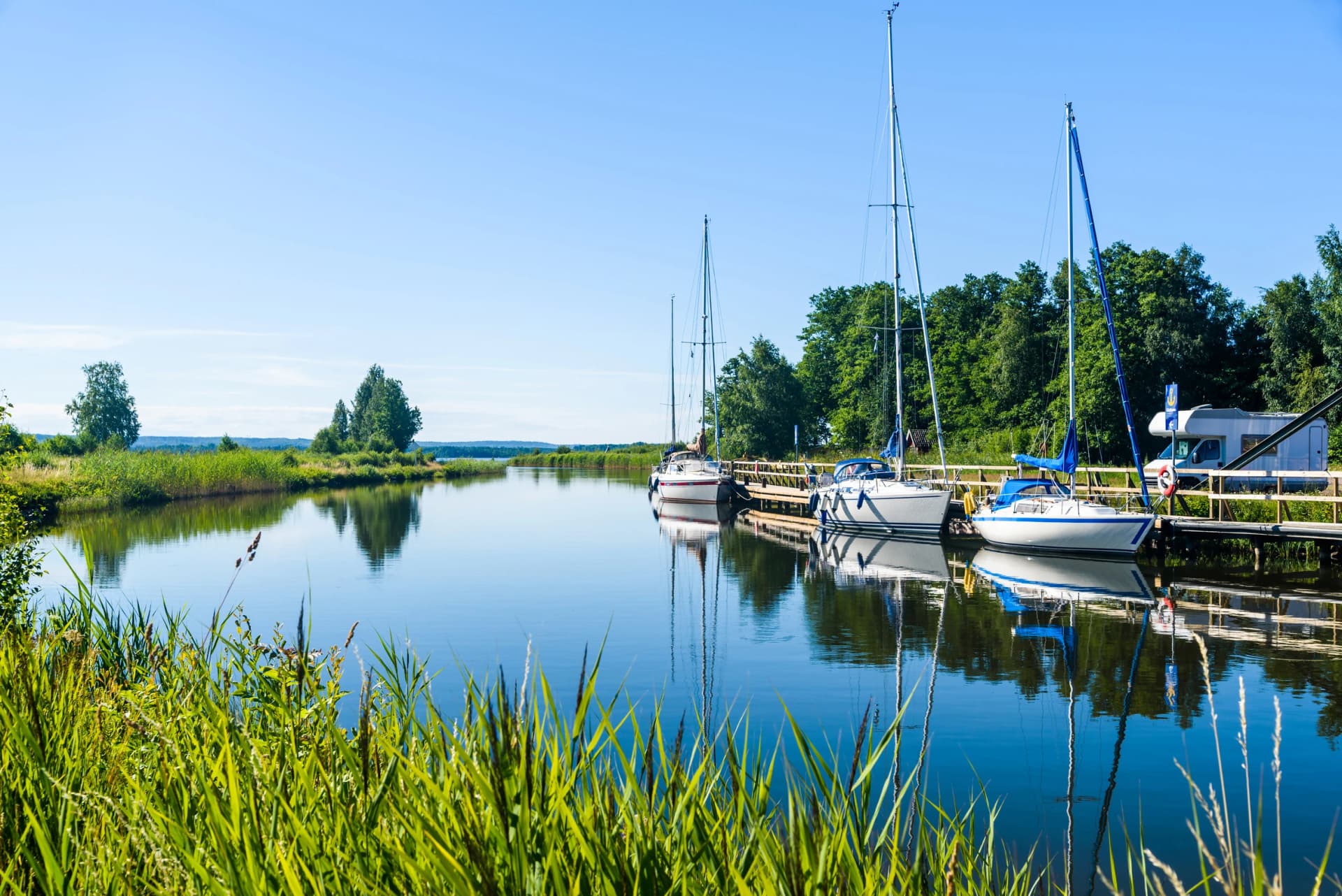 The Gota canal at Tatorp, Sweden, on a sunny summer day. Sailboats moored by the pier.