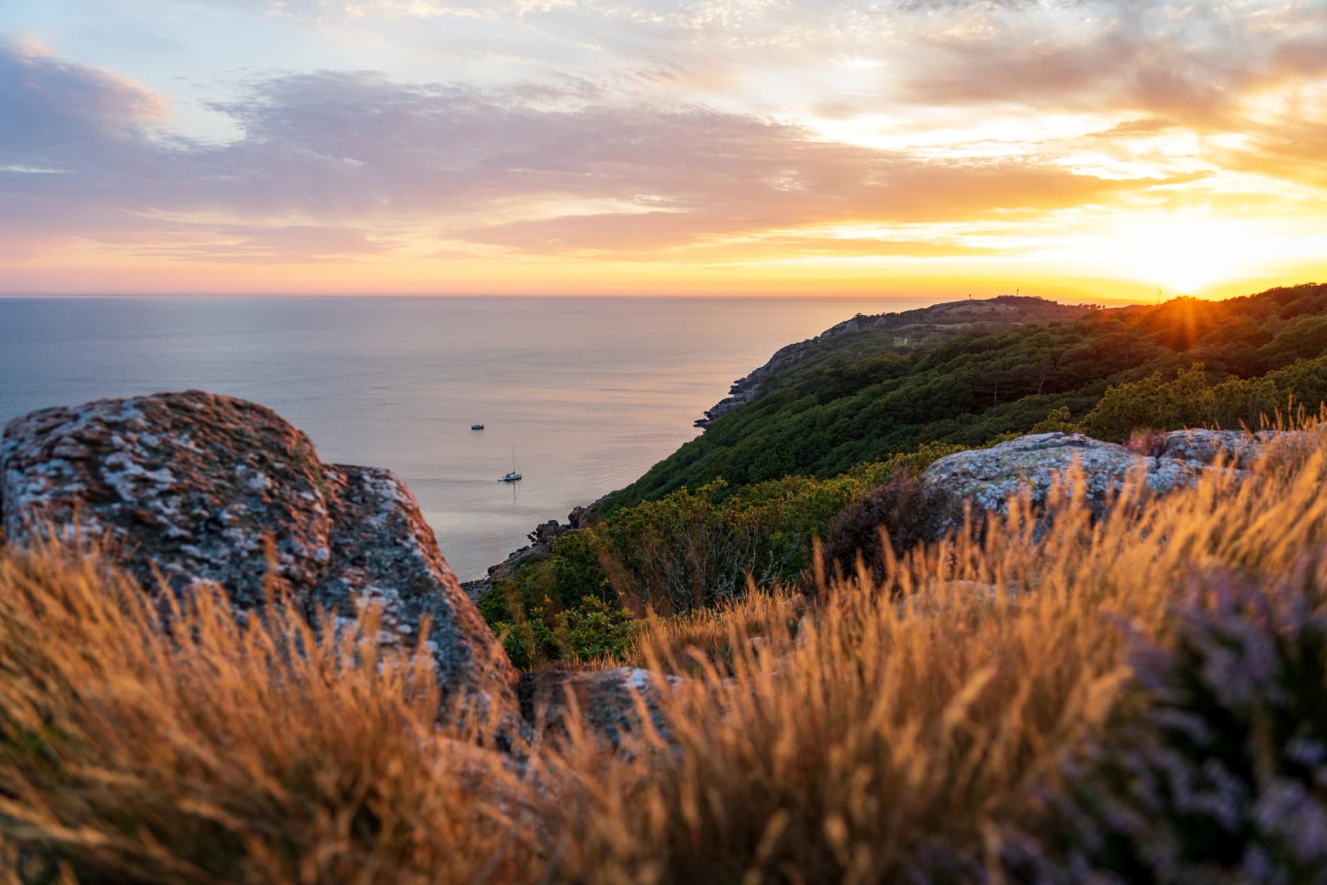 Golden sunset over mountains and sea at Kullaberg nature reserve in south Sweden.
