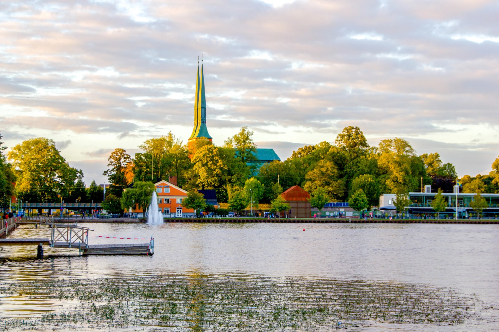 A scenic and empty wooden pier at the swedish lake Trummen in Vaxjo, in the region Smaland, Sweden on a sunny day with some clouds on the sky. Vaxjo is know as the greenest city in Europe