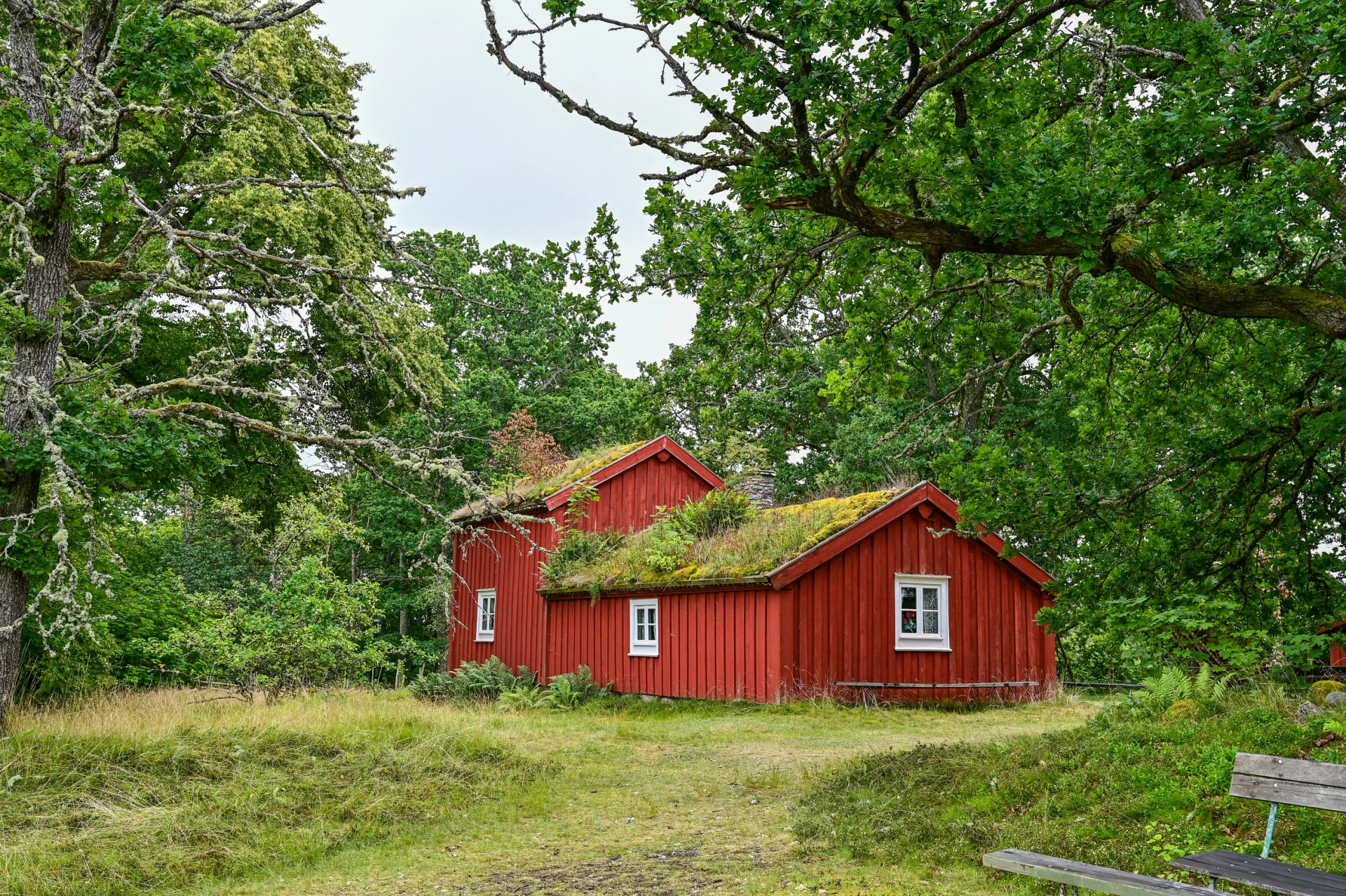 typical, traditional red Swedish house, wooden house with a mossy roof in Hembygdsgard Lunnabacken, a historic homestead near Ugglekull, Urshult, Smaland Sweden