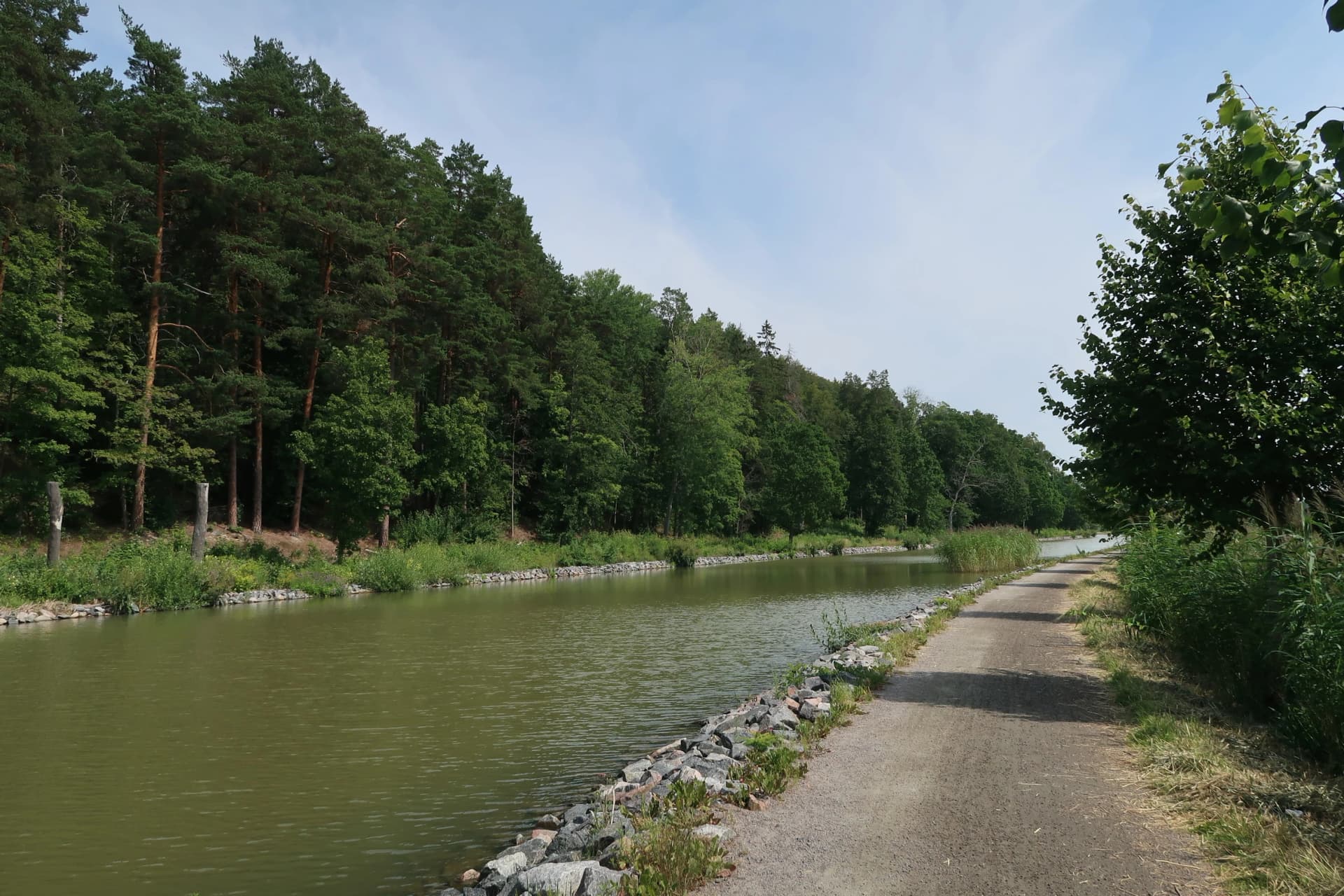 Scenic Walking Path Along Göta Canal in Sweden with Lush Green Trees and Peaceful Waters